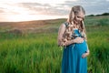 Beautiful tender pregnant woman standing on green grass Royalty Free Stock Photo