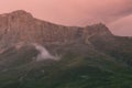 Beautiful tender summer mountain landscape - high pink rocky ridge in soft mist of pink early morning sunlight overcast weather Royalty Free Stock Photo