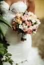 Beautiful tender wedding bouquet of roses and eustoma flowers in hands Royalty Free Stock Photo