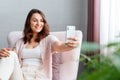 Beautiful tender young smiling caucasian 30s woman taking picture selfie using cell phone near window. Long haired Royalty Free Stock Photo