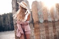 Beautiful tender young woman is posing in straw hat in the sunlight. Countryside landscape, forest nature at the background