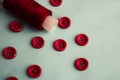 Beautiful texture with lots of round red buttons for sewing, needlework and a coil of thread. Copy space. Flat lay. Blue