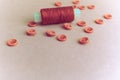 Beautiful texture with many round pink buttons for sewing, needlework and a coil of thread. Copy space. Flat lay. Pink, purple Royalty Free Stock Photo