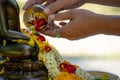 Beautiful Thai cultural. Man pouring water mixed with colourful petal flowers and perfume onto a Buddha image on Songkran festival Royalty Free Stock Photo