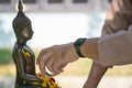 Beautiful Thai cultural. Royal Thai Navy sailor pouring water mixed with colourful petal flowers and perfume onto a Buddha image Royalty Free Stock Photo