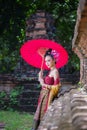 Beautiful Thai girl in traditional dress costume red umbrella as Royalty Free Stock Photo