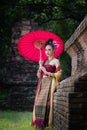 Beautiful Thai girl in traditional dress costume red umbrella as Royalty Free Stock Photo