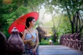 Beautiful Thai girl in traditional dress costume red umbrella as Royalty Free Stock Photo