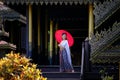 Beautiful Thai girl in traditional dress costume red umbrella as Royalty Free Stock Photo