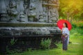 Beautiful Thai girl in traditional dress costume red umbrella as Royalty Free Stock Photo