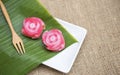 Beautiful Thai layer cake in rose flower shape on fresh green leaf