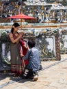 Thai woman with traditional clothes holding an umbrella with a photogrpher at the Wat Arun Temple in BAgkok, Thailand