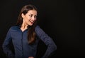 Beautiful thinking excited smiling business woman with folded arms on presentation on black background with empty copy space for