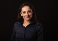 Beautiful thinking toothy laughing business woman with folded arms in blue shirt on black background with empty copy space. Royalty Free Stock Photo