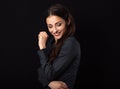 Beautiful thinking toothy laughing business woman with folded arms in blue shirt looking down on black background with empty copy Royalty Free Stock Photo