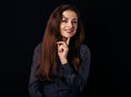 Beautiful thinking toothy smiling business woman with finger under the face in blue shirt on black background with empty copy Royalty Free Stock Photo