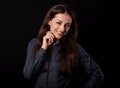 Beautiful thinking toothy smiling business woman with folded arms in blue shirt on black background with empty copy space for text Royalty Free Stock Photo