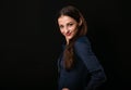 Beautiful thinking toothy smiling business woman with folded arms in blue shirt on black background with empty copy space for text Royalty Free Stock Photo