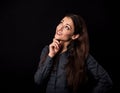 Beautiful thinking toothy smiling business woman with folded arms looking up in blue shirt on black background with empty copy Royalty Free Stock Photo