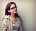 Beautiful thinking young woman in glasses looking up. Vintage po