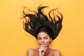Beautiful thinking young woman lies isolated on yellow background. Healthy hair concept Royalty Free Stock Photo