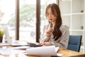 A beautiful and thoughtful Asian businesswoman is focusing on her work at her desk Royalty Free Stock Photo