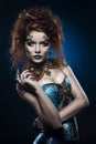 A beautiful thoughtful redhead cosplay girl wearing a Victorian-style steampunk costume with big breasts in a deep neckline.