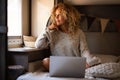 Beautiful thoughtful woman with curly hair and knitted top daydreaming or thinking of ideas, good future plans while looking out Royalty Free Stock Photo