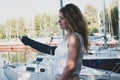 Woman with long hair in white blouse looking away near sailboats in yachts club Royalty Free Stock Photo