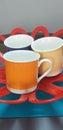 Beautiful three colorful mugs in basket. Royalty Free Stock Photo