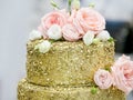 Beautiful three-story golden wedding cake decorated with flowers