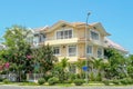 Beautiful three-story house with palm trees, trees, and landscape design in the summer