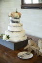 Beautiful three tiered wedding cake with roses and dirty icing Royalty Free Stock Photo