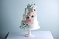 Beautiful three tiered white wedding cake decorated with flowers sugar pink peonies. Concept of elegant holiday desserts Royalty Free Stock Photo