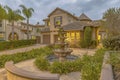 Beautiful tiered fountain at the garden of a home against sky with gray clouds Royalty Free Stock Photo