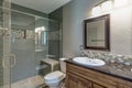 Beautiful tiled shower in remodeled bathroom dark countertop gray blue walls