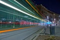 Beautiful timelapse shot of car lights on the asphalt road in front of a building at night in Milan