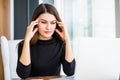 Beautiful tired business woman is holding eyeglasses and massaging while working in office Royalty Free Stock Photo