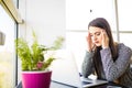 Beautiful tired business woman is holding massaging her head while working in office Royalty Free Stock Photo