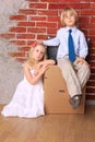 Beautiful tired children sitting on suitcases