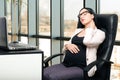 Beautiful tired pregnant woman in the office Royalty Free Stock Photo