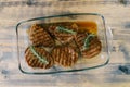 Beautiful toasted steaks in a glass plate on a wooden background, in their own juice and sprigs of rosemary. Royalty Free Stock Photo