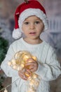 Beautiful toddler boy, holding christmas light string, looking at camera Royalty Free Stock Photo