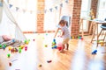 Beautiful toddler boy playing with basketball ball and plastic basket at kindergarten Royalty Free Stock Photo