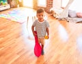 Beautiful toddler boy playing tennis with red racket and ball at kindergarten Royalty Free Stock Photo