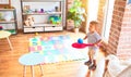 Beautiful toddler boy playing tennis with red racket and ball at kindergarten Royalty Free Stock Photo