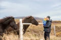 Beautiful toddler child with dad, fondle horses in the nature, early in the morning on a windy autumn day