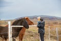 Beautiful toddler child with dad, fondle horses in the nature, early in the morning on a windy autumn day