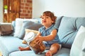 Beautiful toddler child girl holding jar of cookies sitting on the sofa Royalty Free Stock Photo