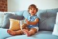 Beautiful toddler child girl holding jar of cookies sitting on the sofa Royalty Free Stock Photo